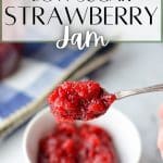 A close up of a spoon holding gelled strawberry jam.