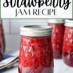 A jar of strawberry jam on a marble background