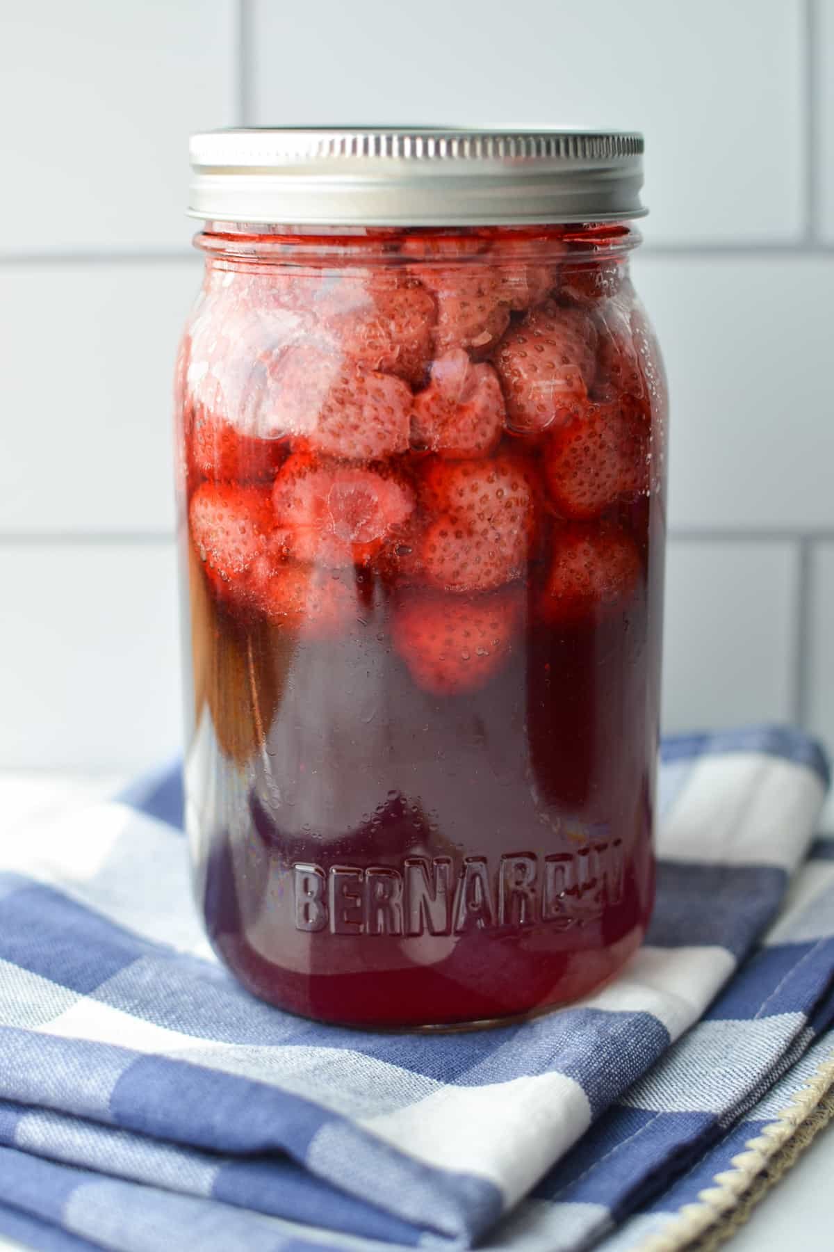 A jar of strawberries that has been home canned.