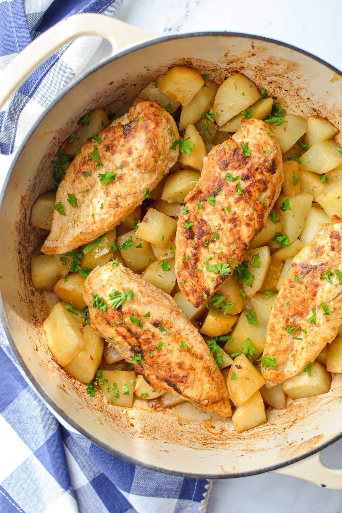 A Dutch Oven filled with chicken breast and potatoes.