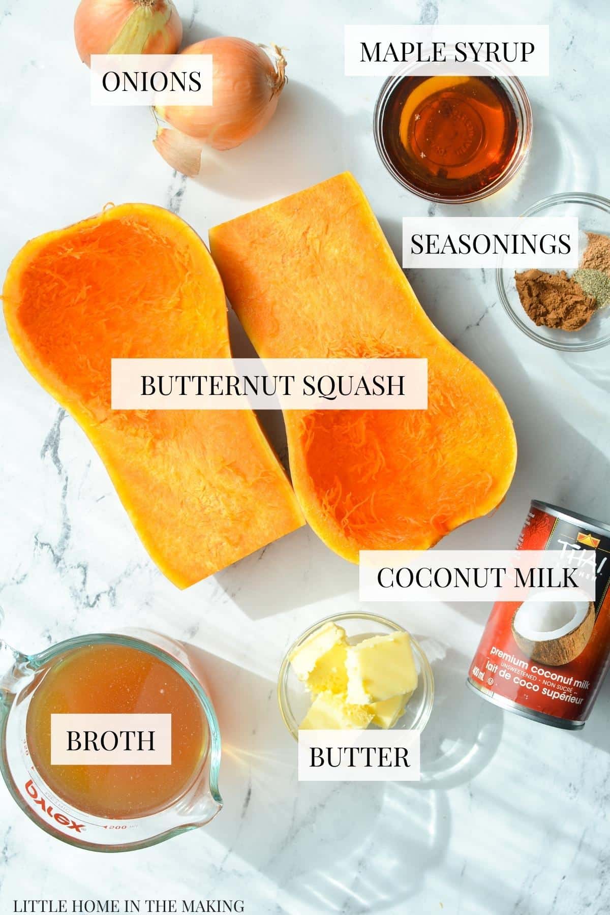 The ingredients needed to make butternut squash soup, including butter, broth, butternut squash, onions, maple syrup, and coconut milk.