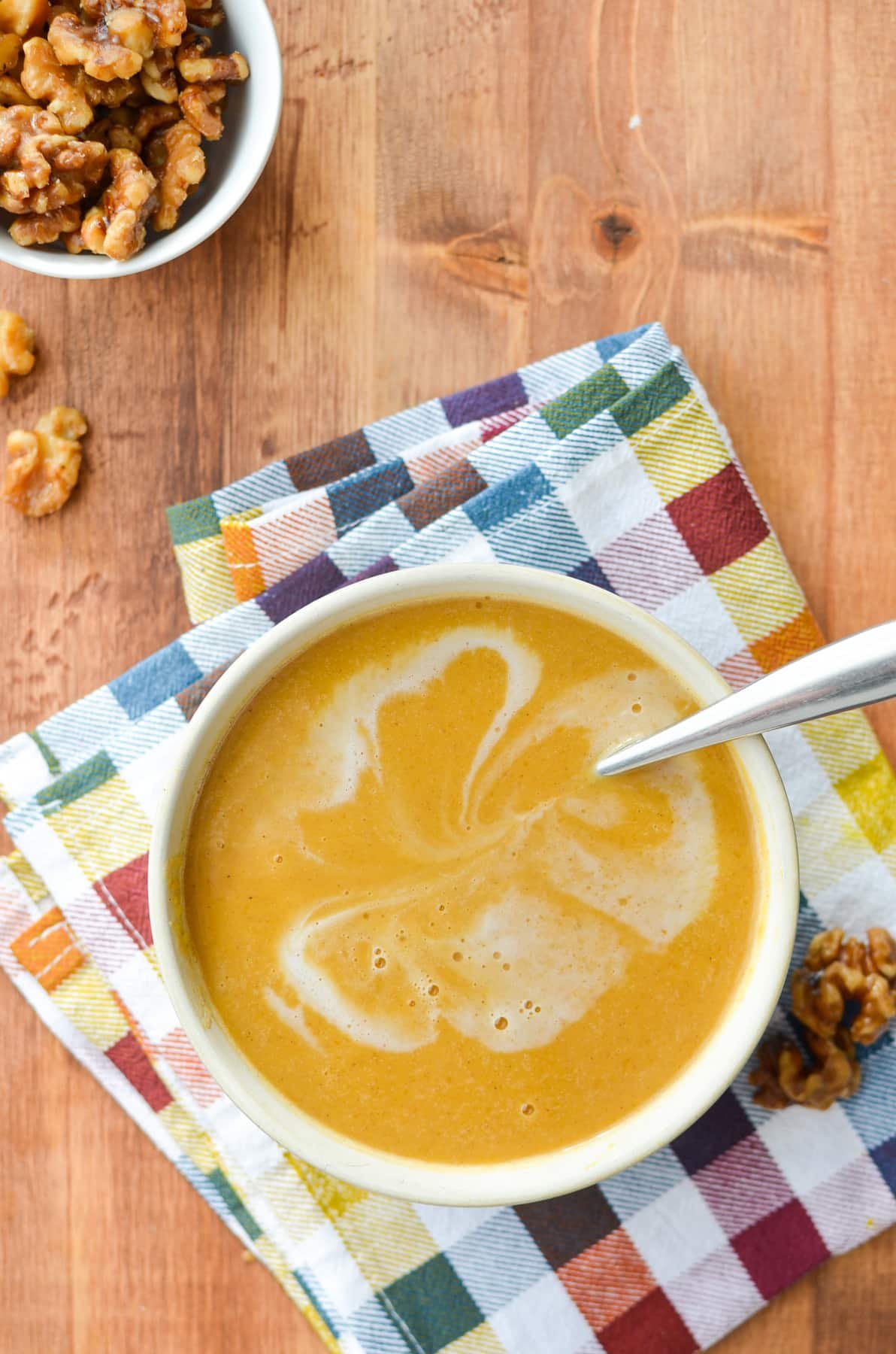 An overhead image of butternut squash soup with a coconut swirl.