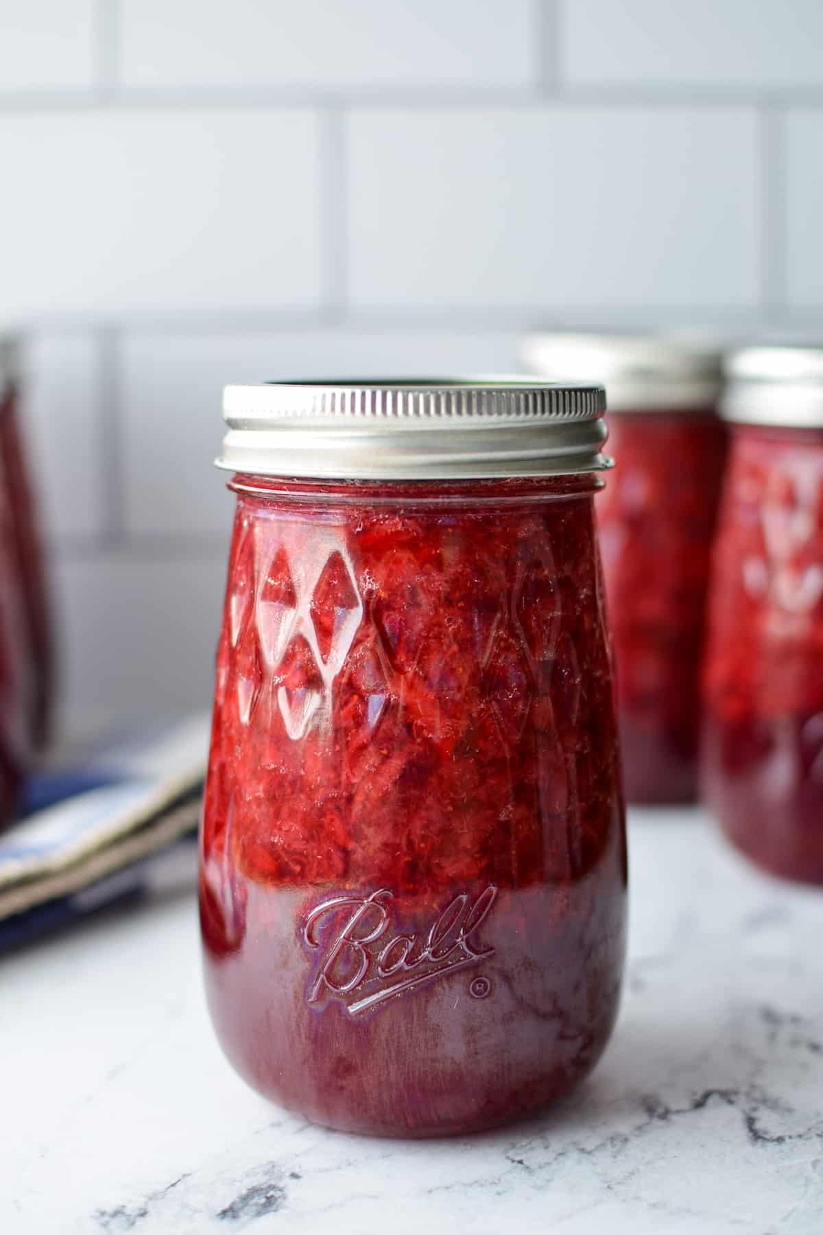 A close up of a jar of homemade strawberry jam.