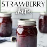 Jars of strawberry jam on a countertop.