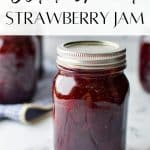 A jar of jam on a white marble background.