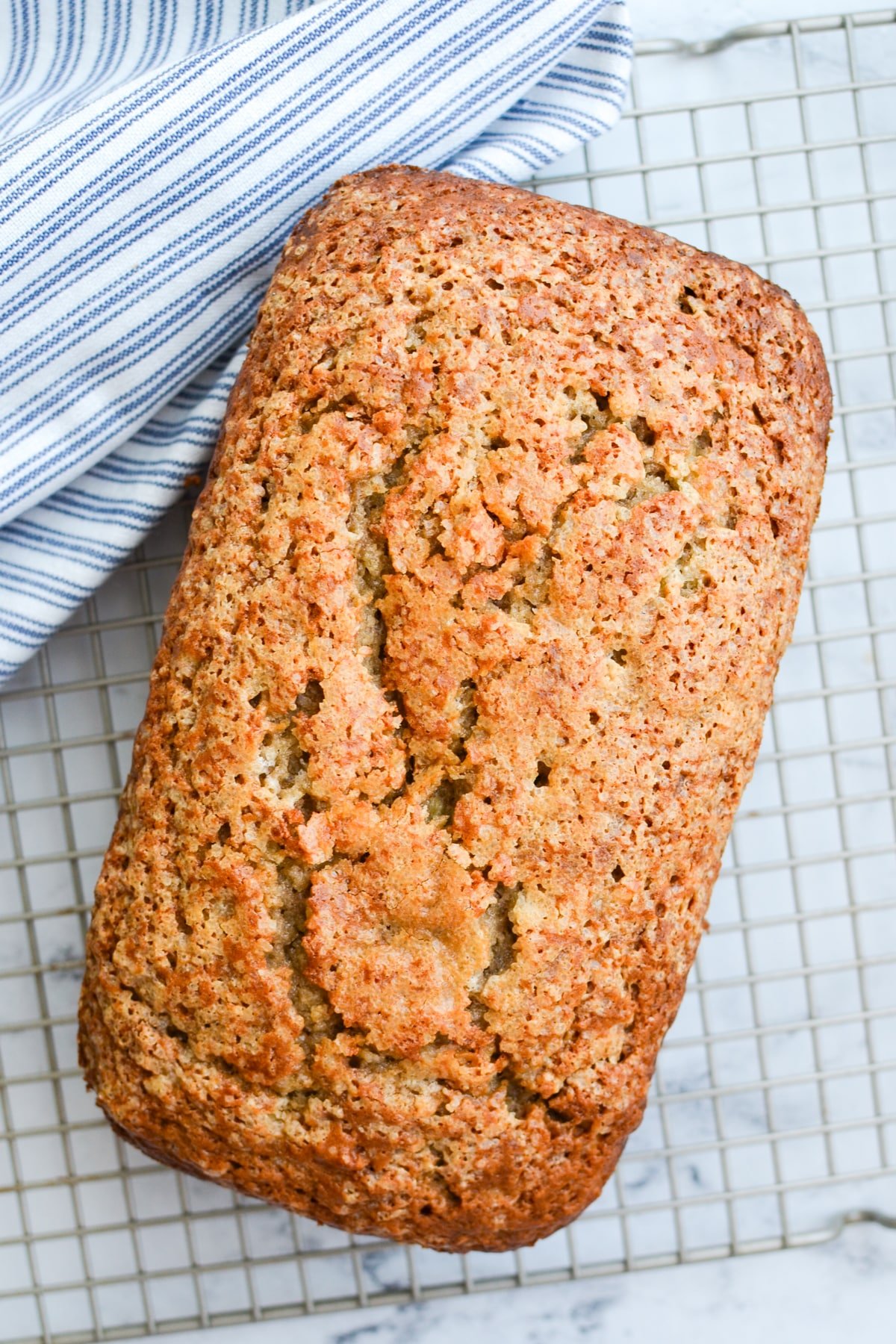 A loaf of banana bread on a cooling rack.