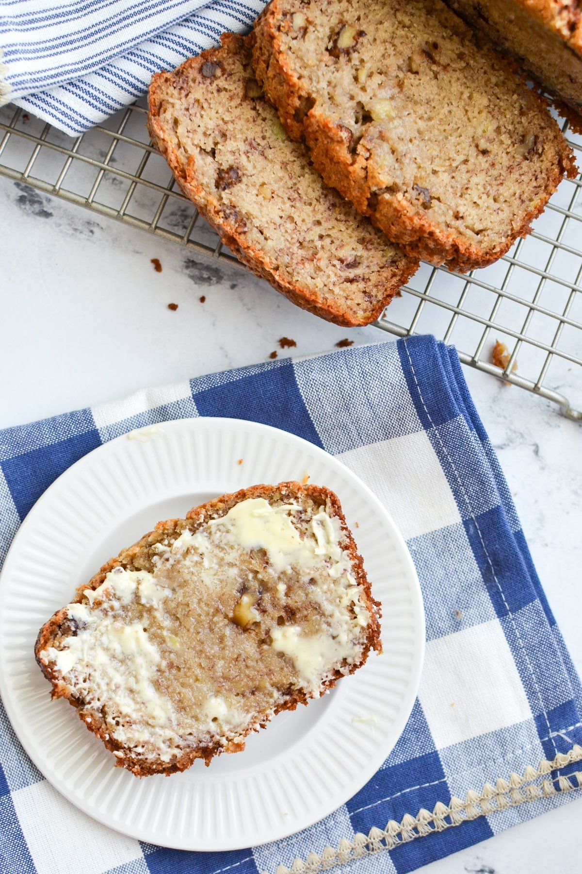 A slice of banana bread spread with butter.