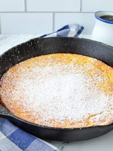 A cast iron skillet with a baked Dutch baby (German pancake) inside.