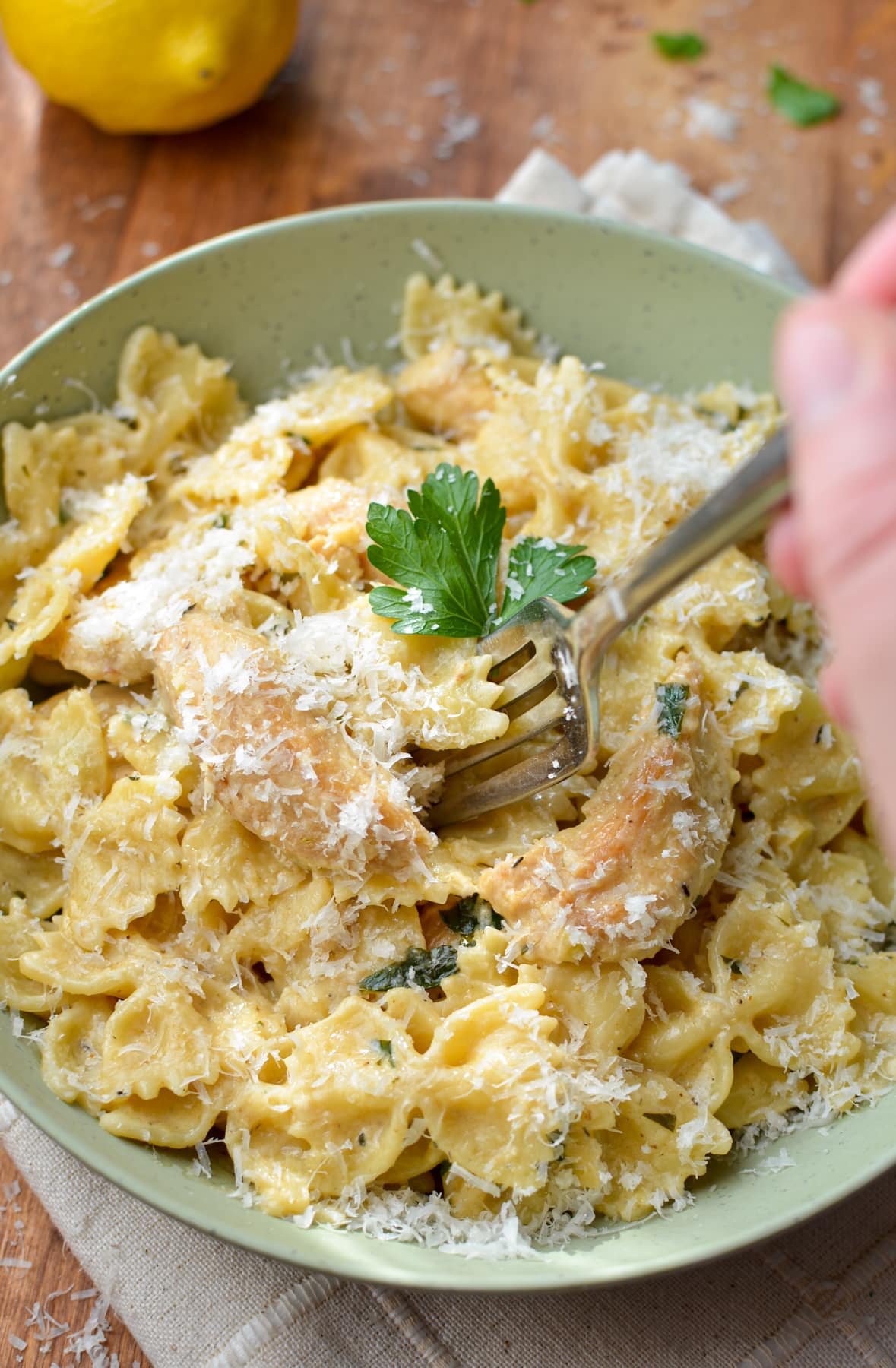 A fork taking a portion of farfalle with a cream sauce.