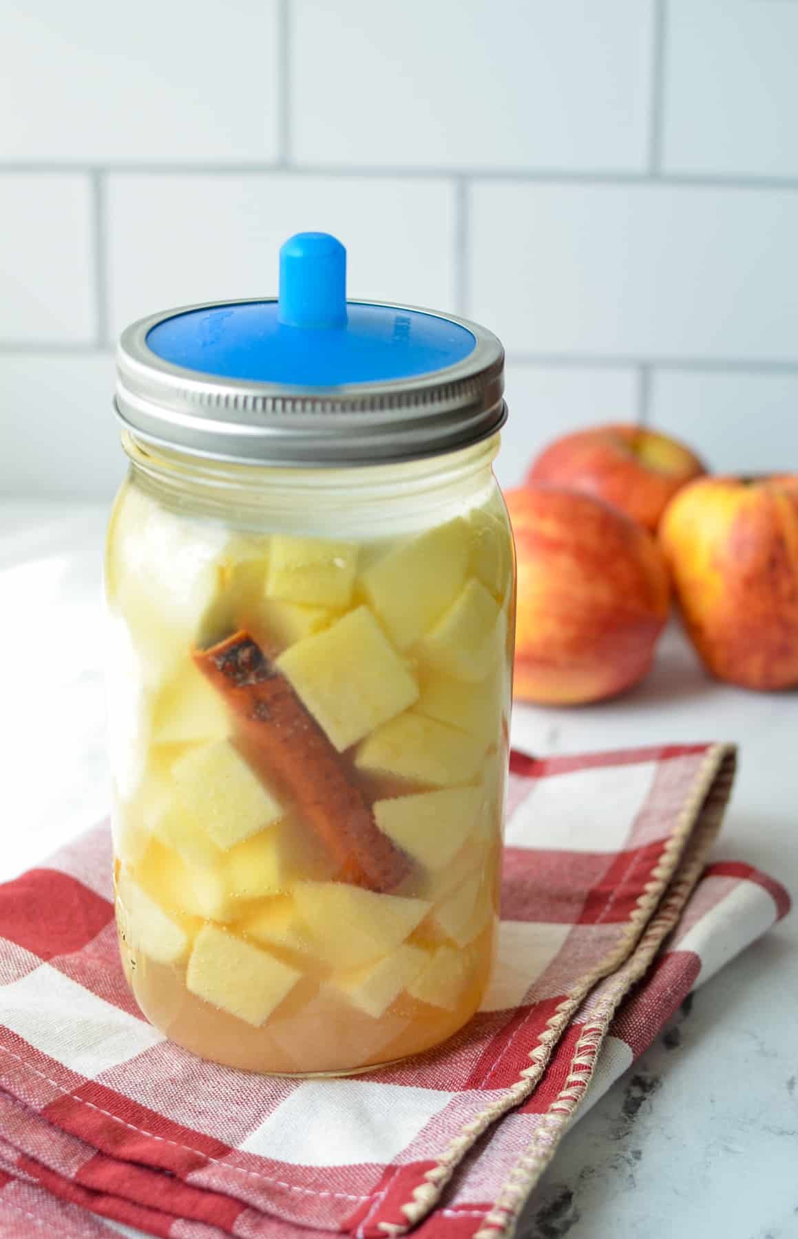 A jar of apples fermenting on the counter.