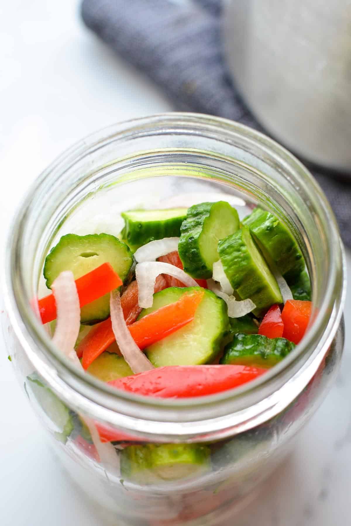 A jar of sliced vegetables, ready to have brine poured over them.