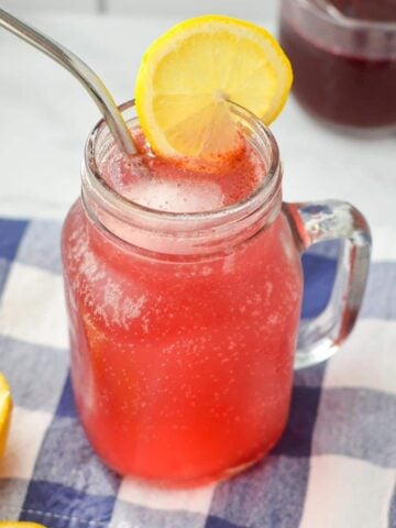 A jar filled with a pinkish purple drink.