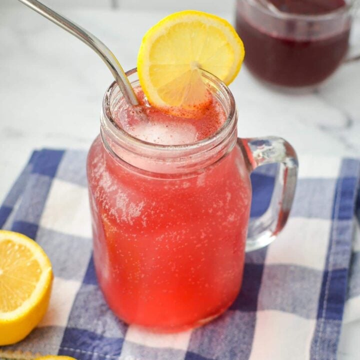 A jar filled with a pinkish purple drink.