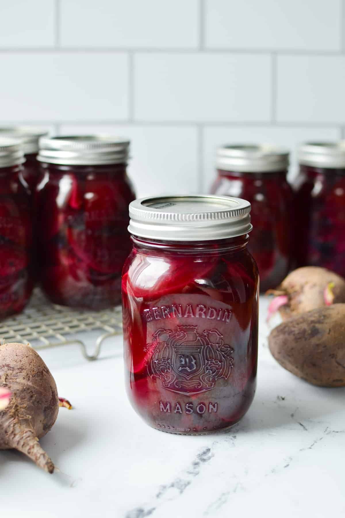 Jars of canned foods on a marble countertop.