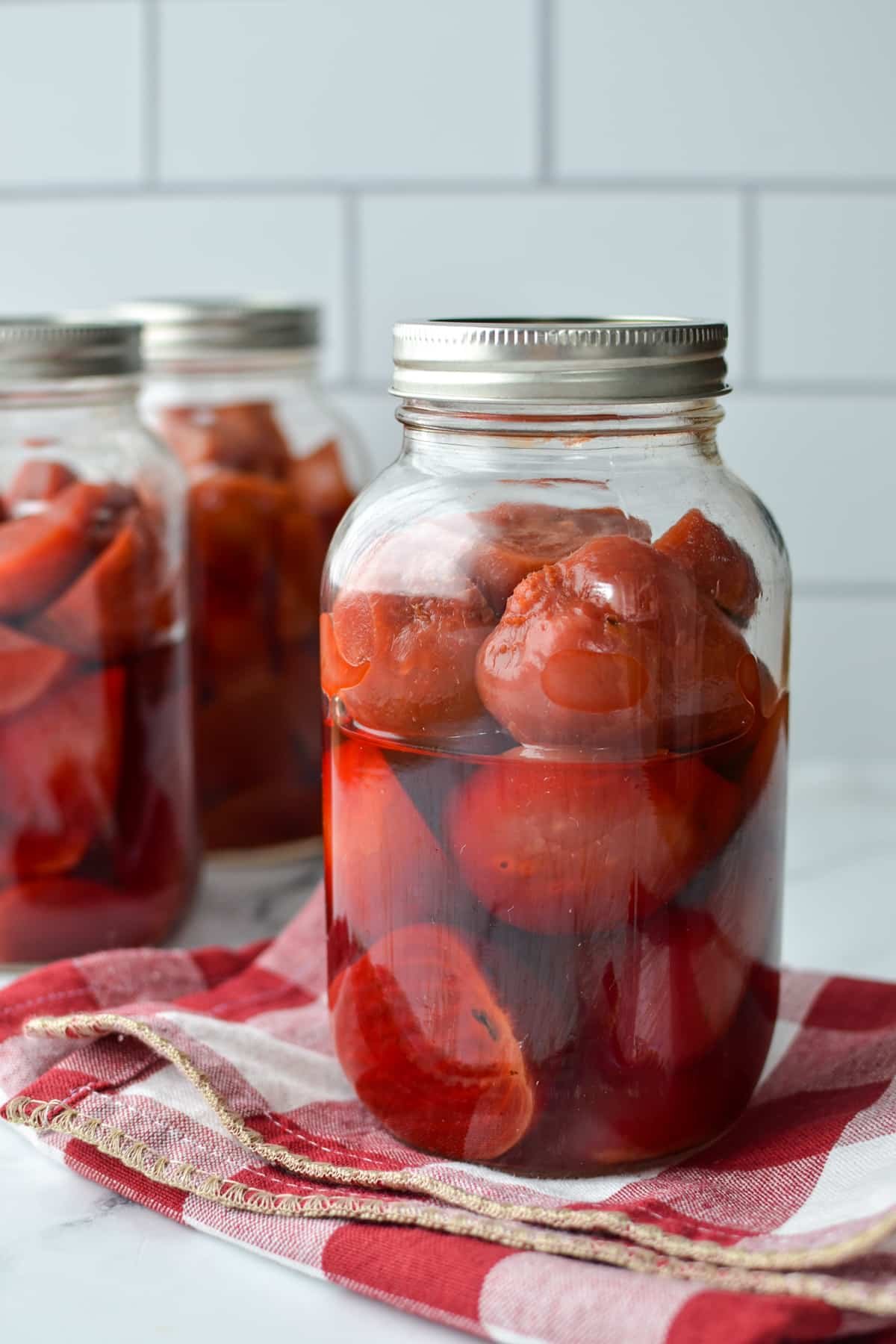 Jars of halved beets in liquid.