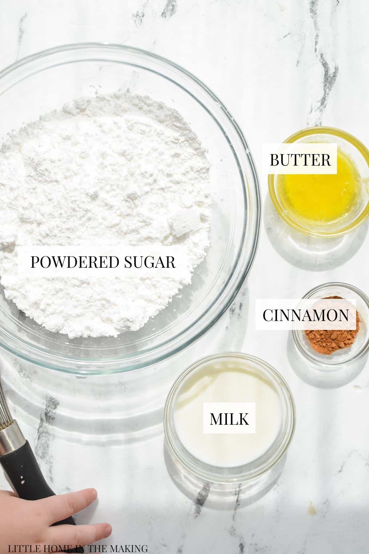 The ingredients needed to make a simple frosting, including powdered sugar and milk.
