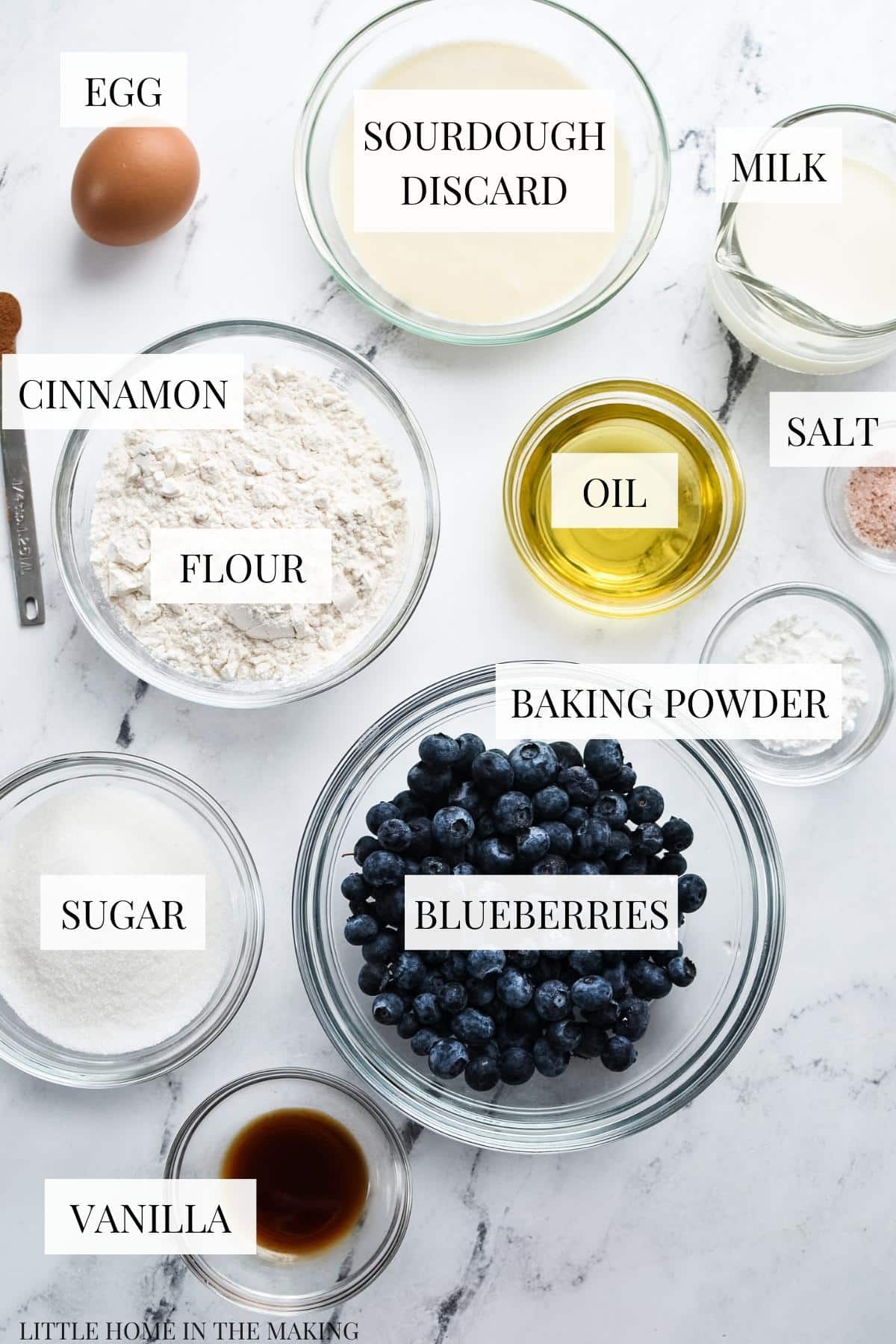 The ingredients needed to make sourdough blueberry bread, including blueberries, flour, and oil.