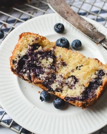 A slice of blueberry quick bread on a plate.