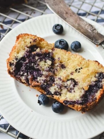 A slice of blueberry quick bread on a plate.