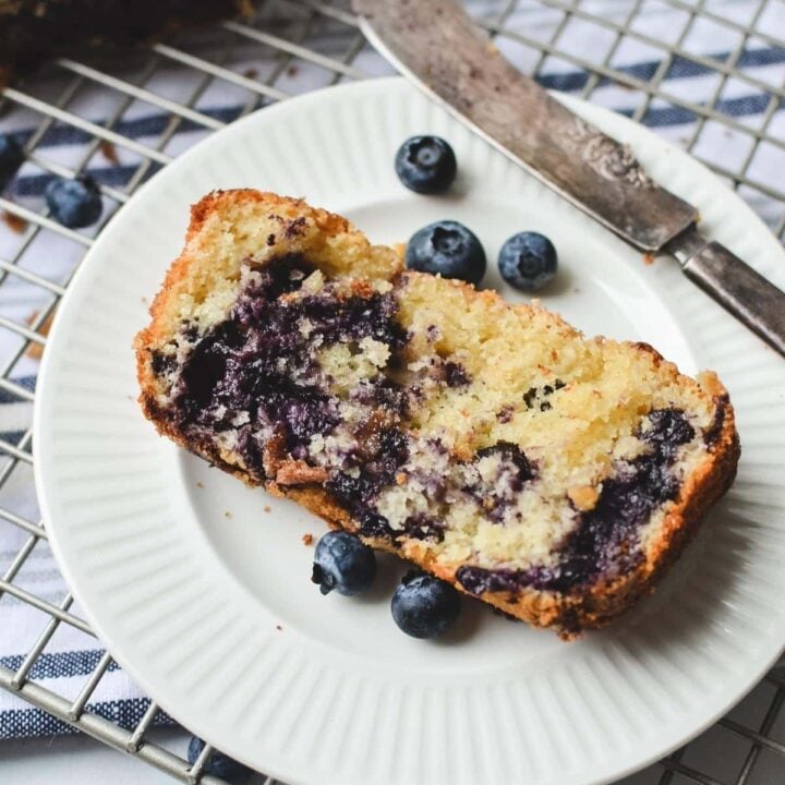 A slice of blueberry quick bread on a plate.