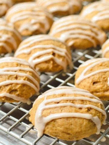 Pumpkin cookies cooling on a wire rack.