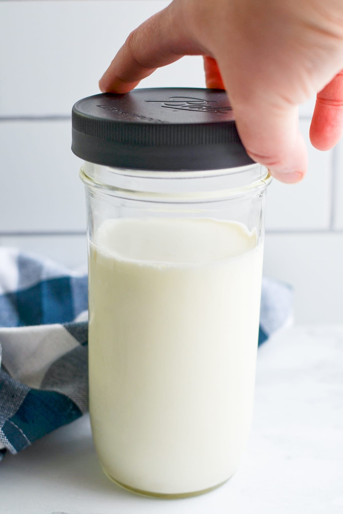 Adding a lid to a jar of kefir.