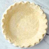 A pie crust fitted into a pie plate with fluted edges.