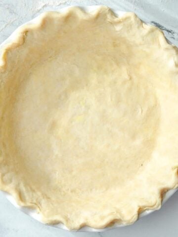 A pie crust fitted into a pie plate with fluted edges.