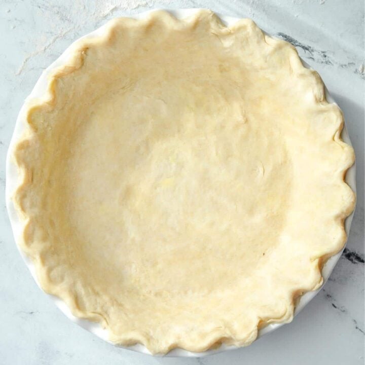 A pie crust fitted into a pie plate with fluted edges.