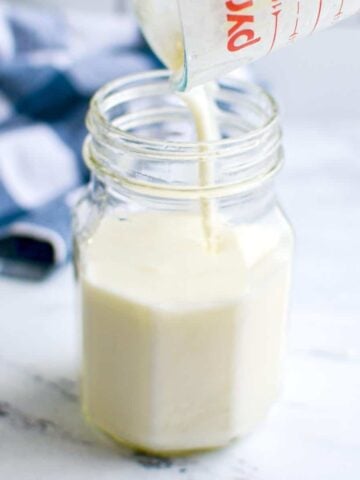 A jar with kefir being poured into it.