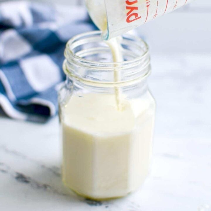 A jar with kefir being poured into it.