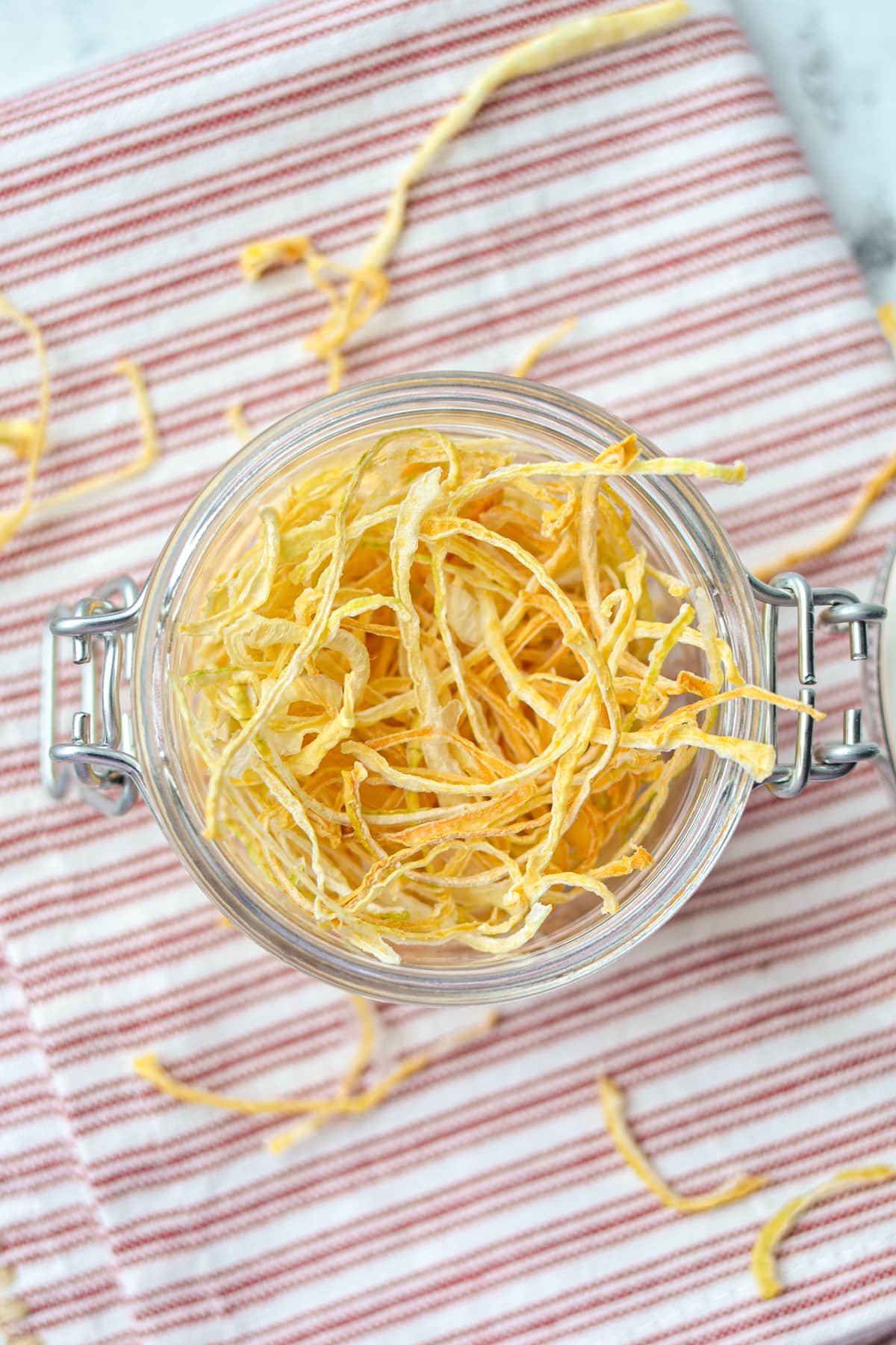 An overhead view of a jar filled with dried onion pieces.