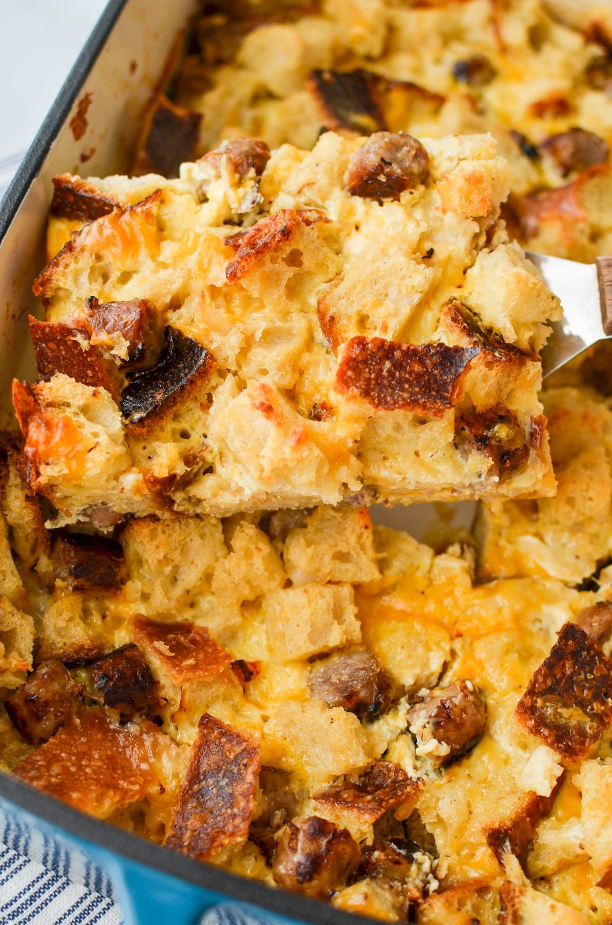 Lifting a square of a breakfast casserole from a baking dish.