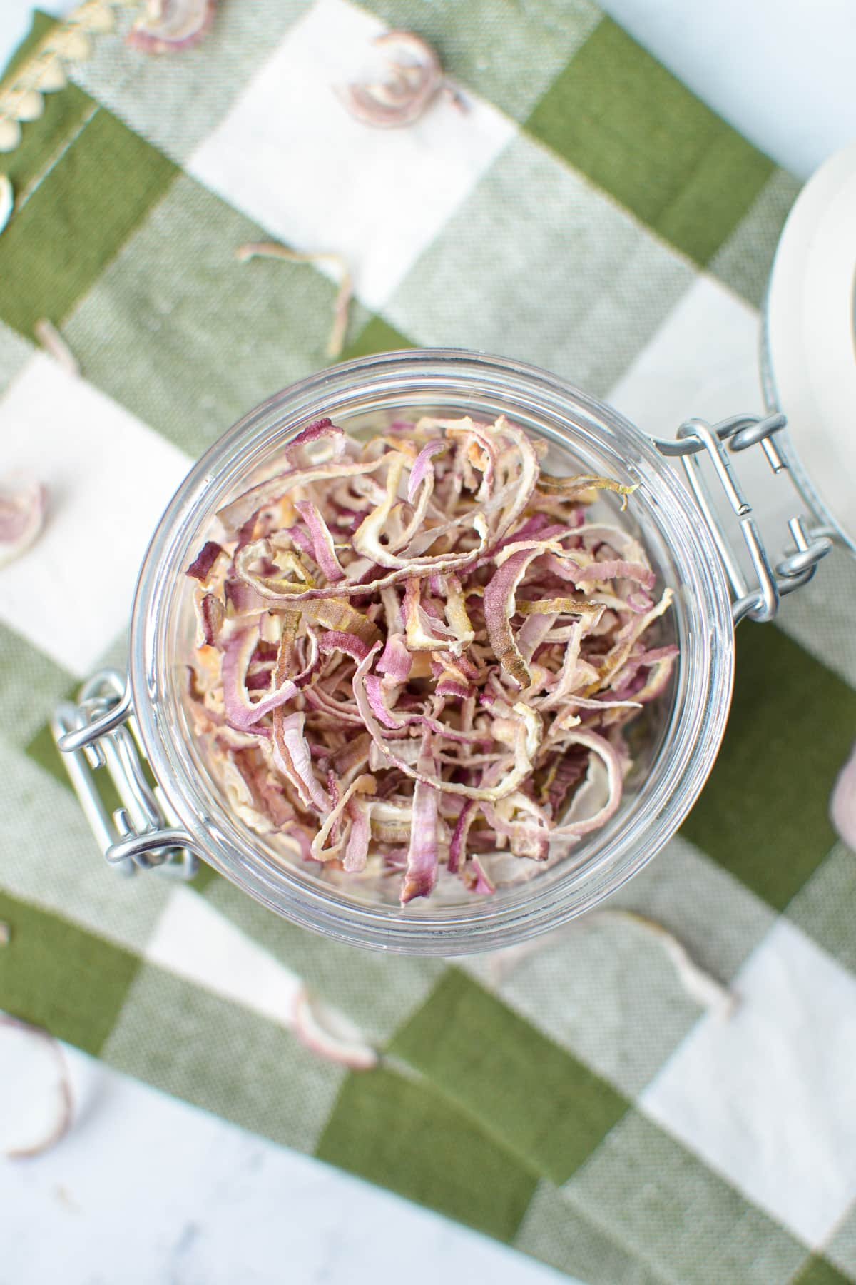 An overhead view of a small jar filled with dried shallots.