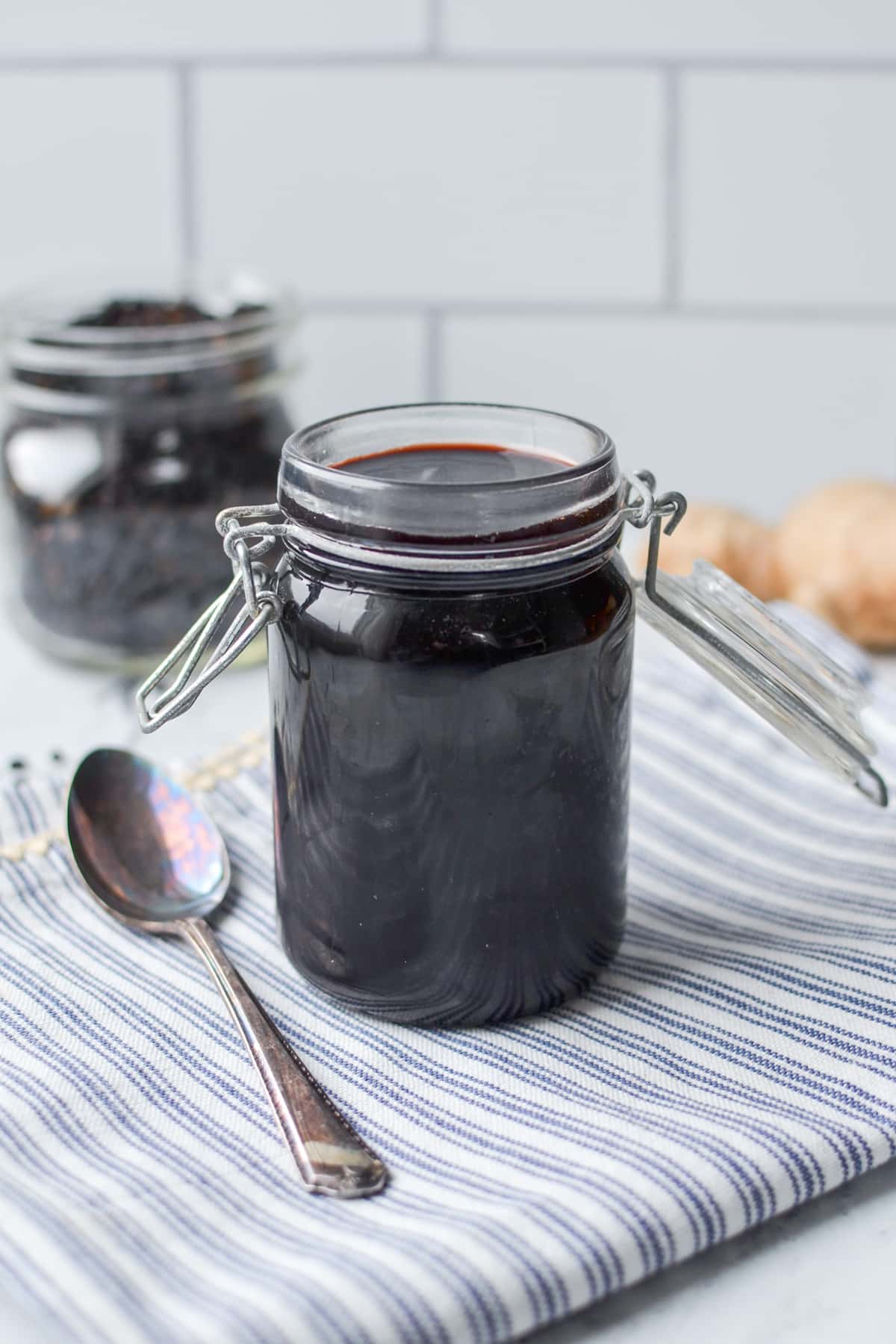 A jar of elderberry syrup on a blue napkin.