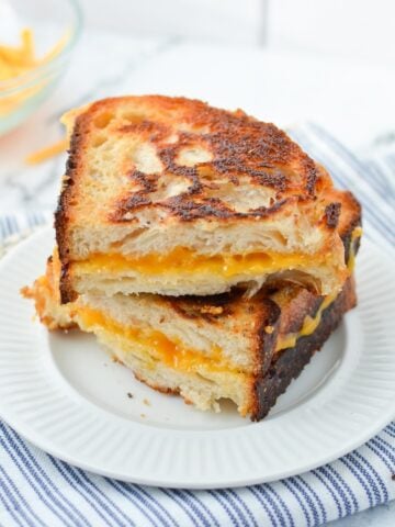 Two slices of grilled cheese stacked on top of one another.