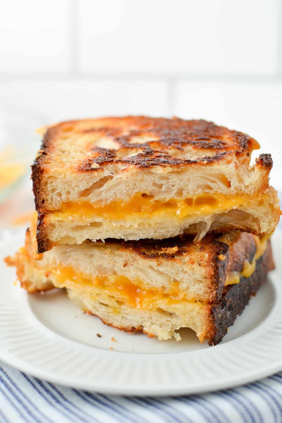 Two halves of a sourdough grilled cheese sandwich, stacked on top of each other.
