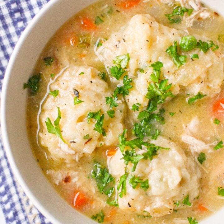 A bowl of chicken stew with dumplings on top.