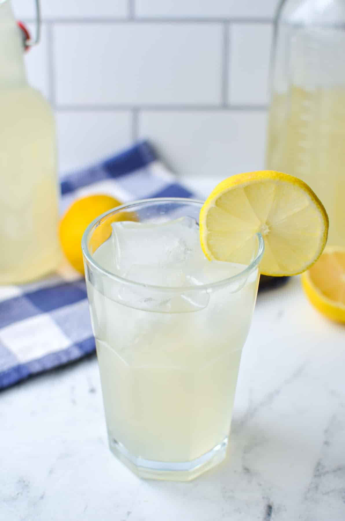 A glass of lemonade garnished with a slice of lemon.