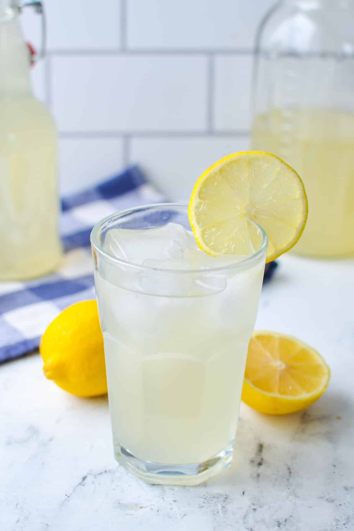 A glass of homemade lemonade garnished with a slice of lemon.