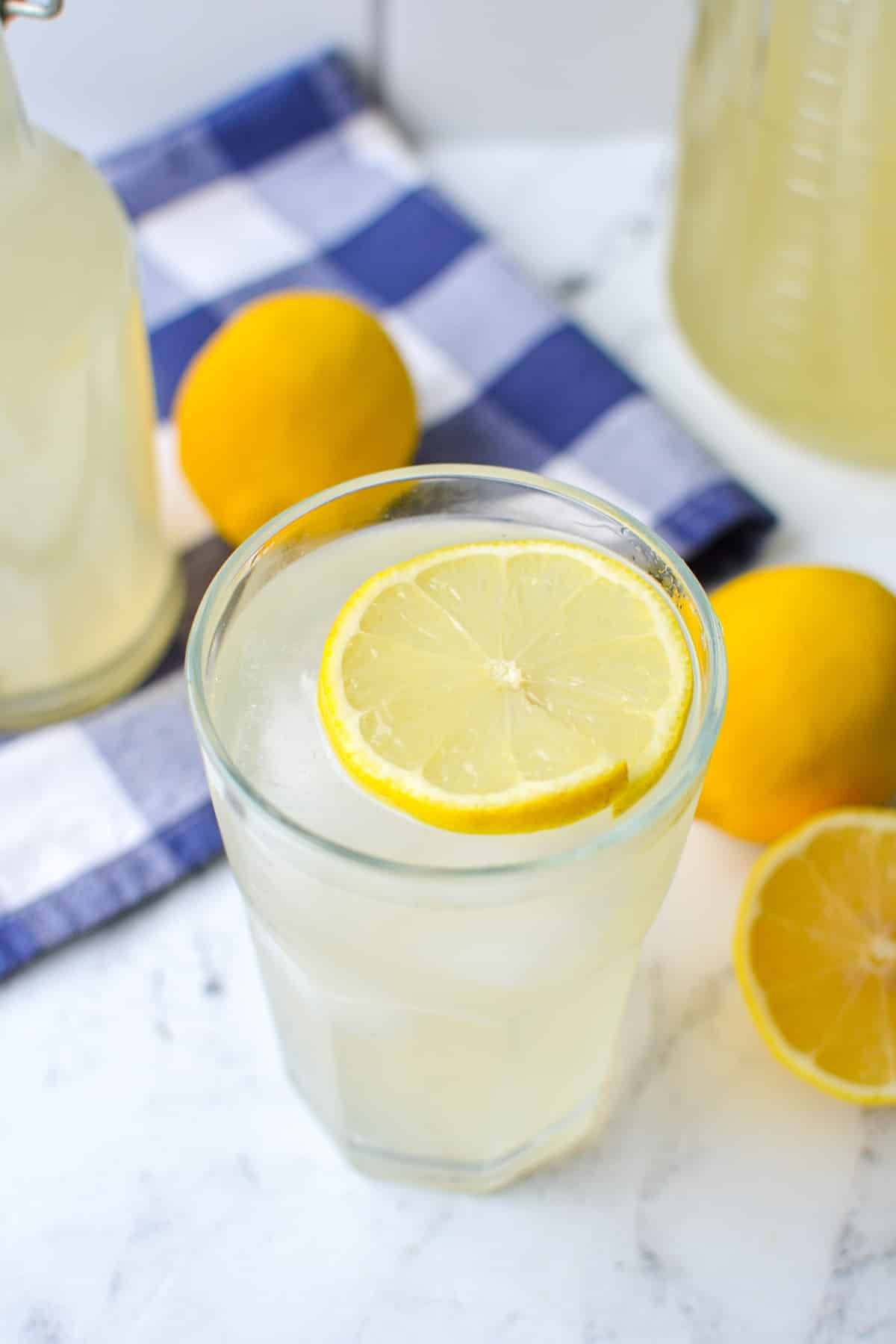A glass of lemonade with a slice of lemon on top.