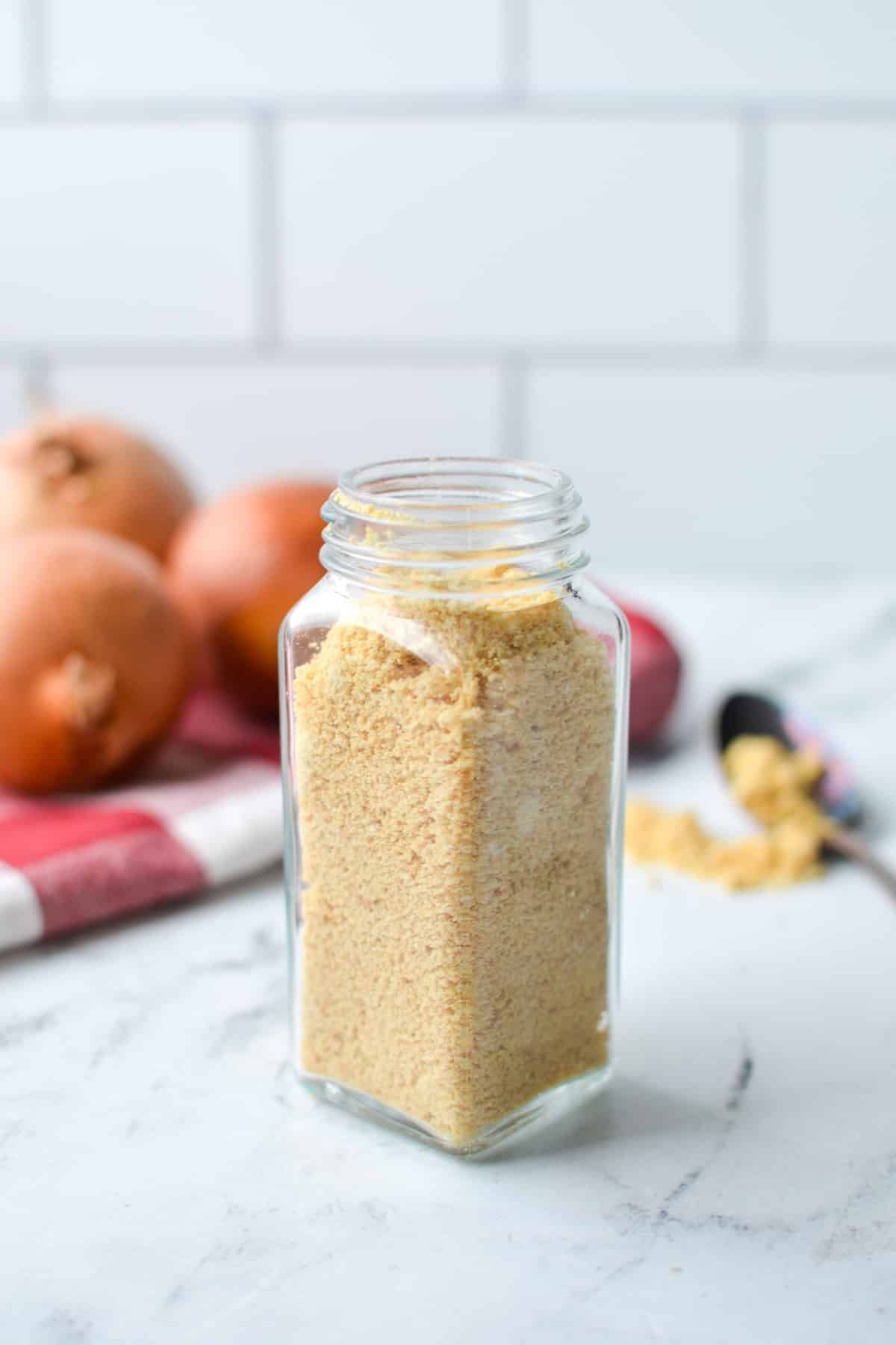 A jar of homemade onion powder on a counter.