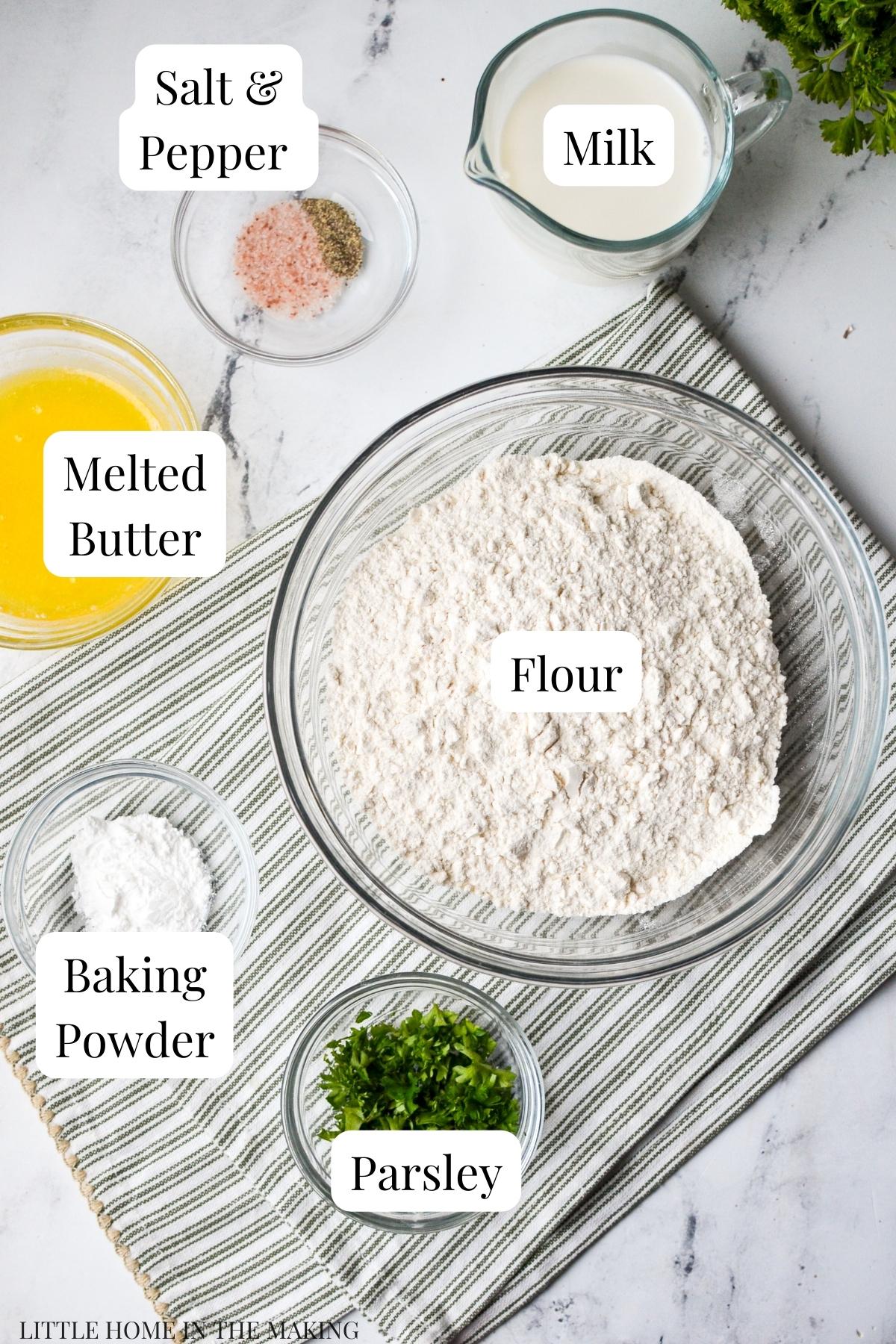 An overhead view of ingredients for dumplings: flour, butter, baking powder, etc.