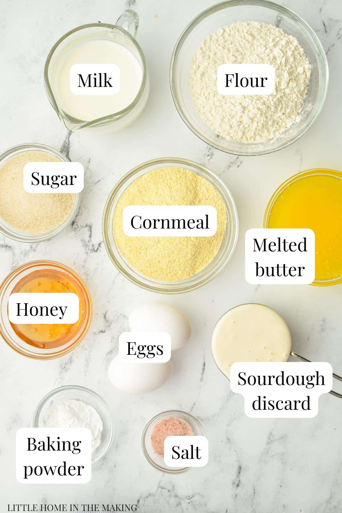 The ingredients needed to make corn muffins: cornmeal, flour, butter, honey, etc.