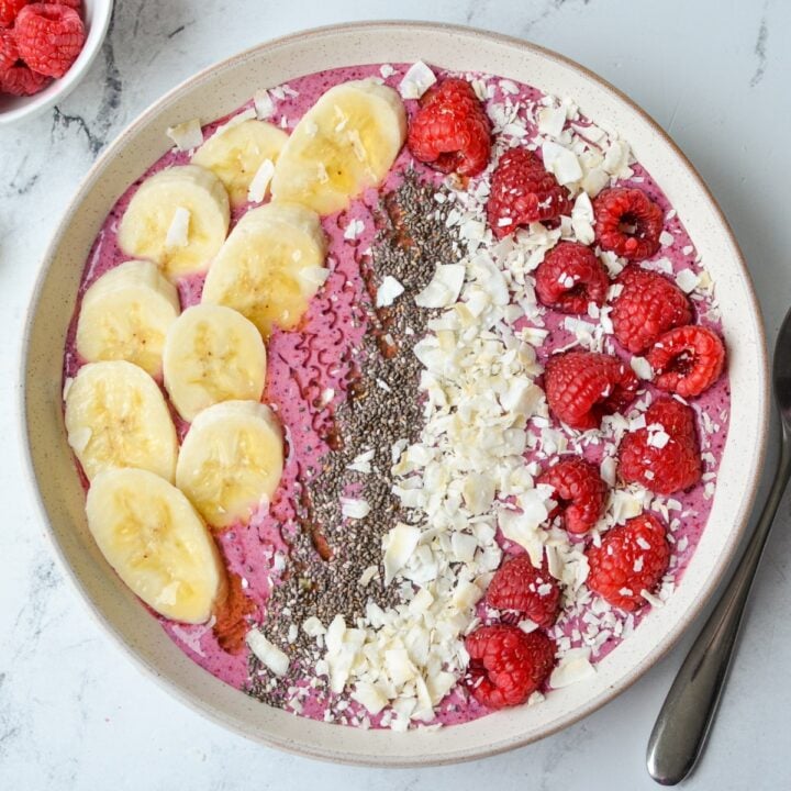 An overhead shot of a smoothie bowl, topped with fruit, chia, and coconut.