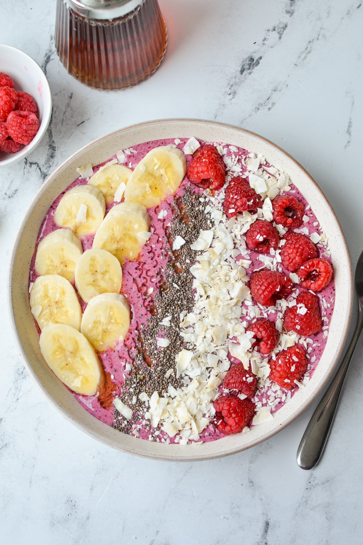 A smoothie bowl, topped with fruit, chia, and coconut.