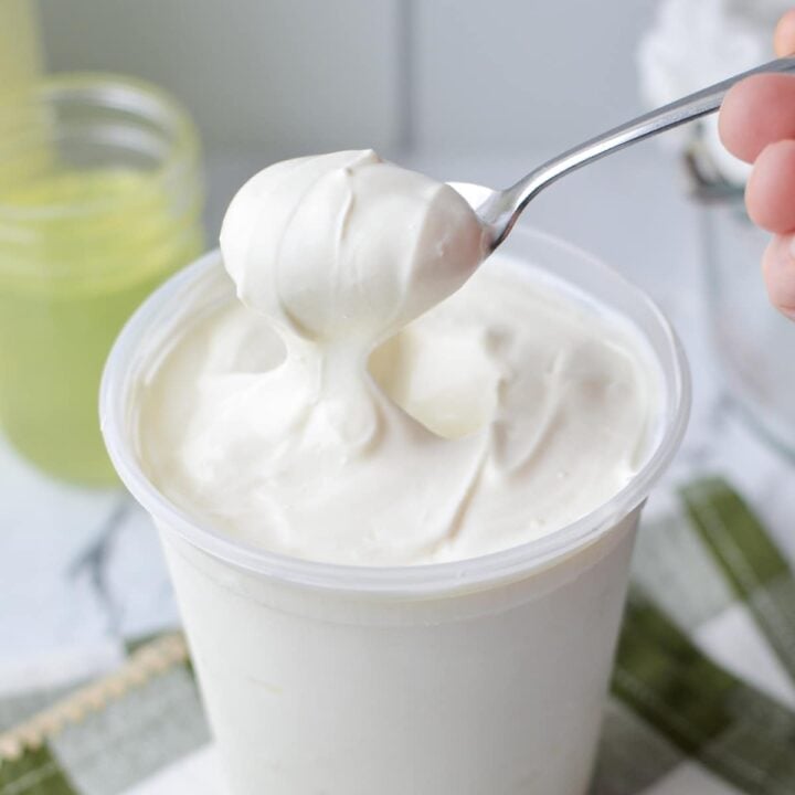 A spoon scooping out a portion of homemade Greek yogurt.