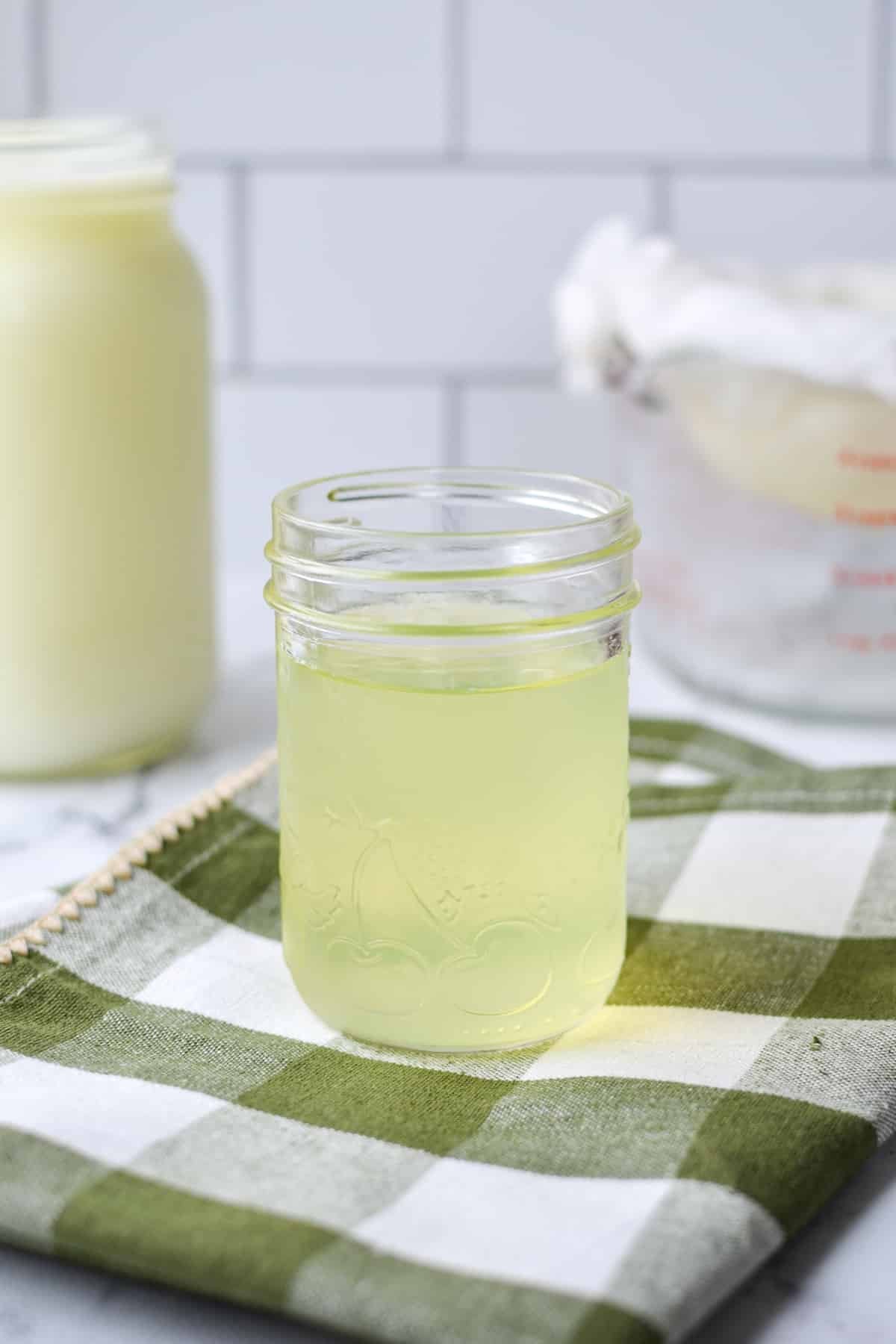 A jar of whey that has been reserved from yogurt.