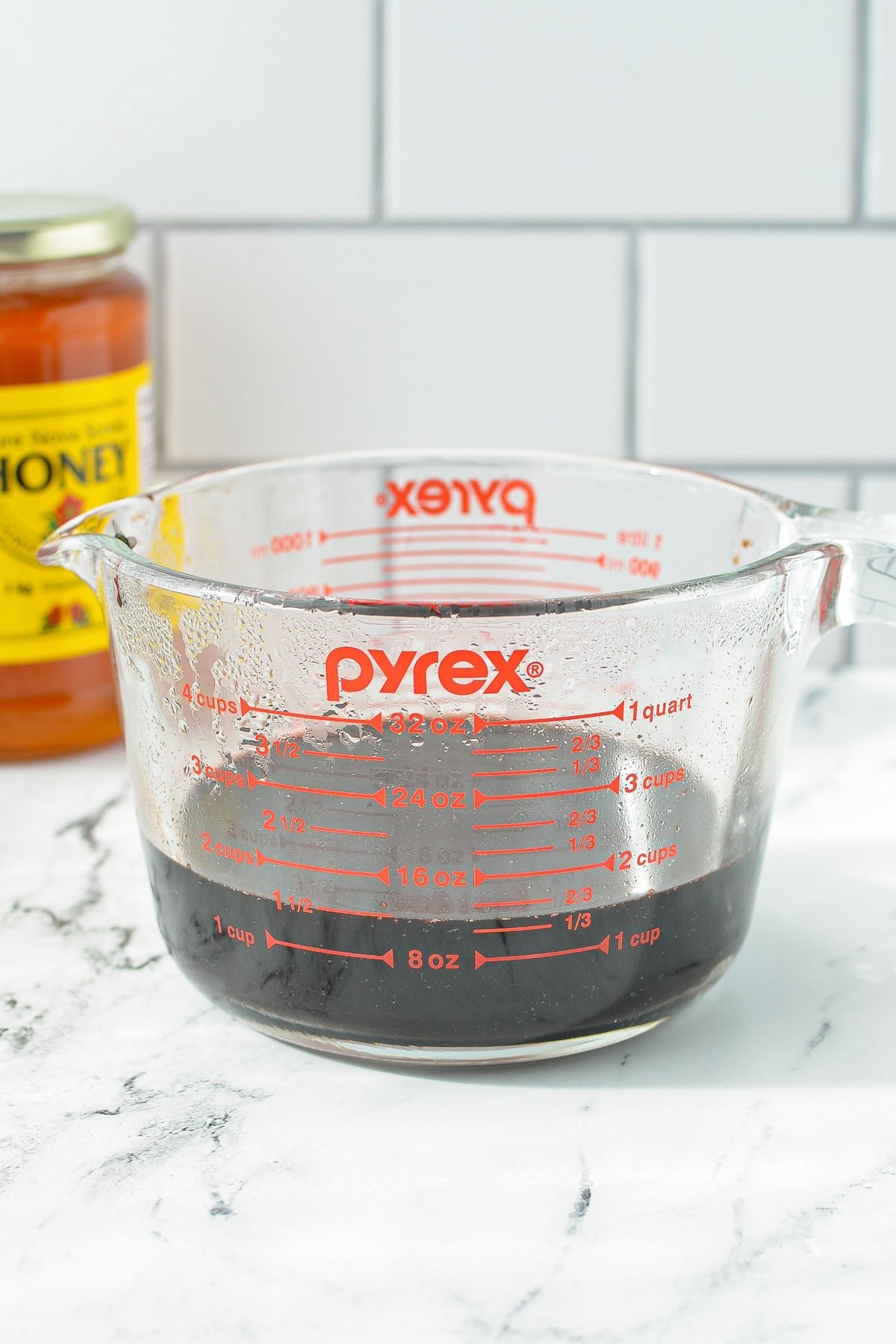 A measuring cup filled with elderberry juice.