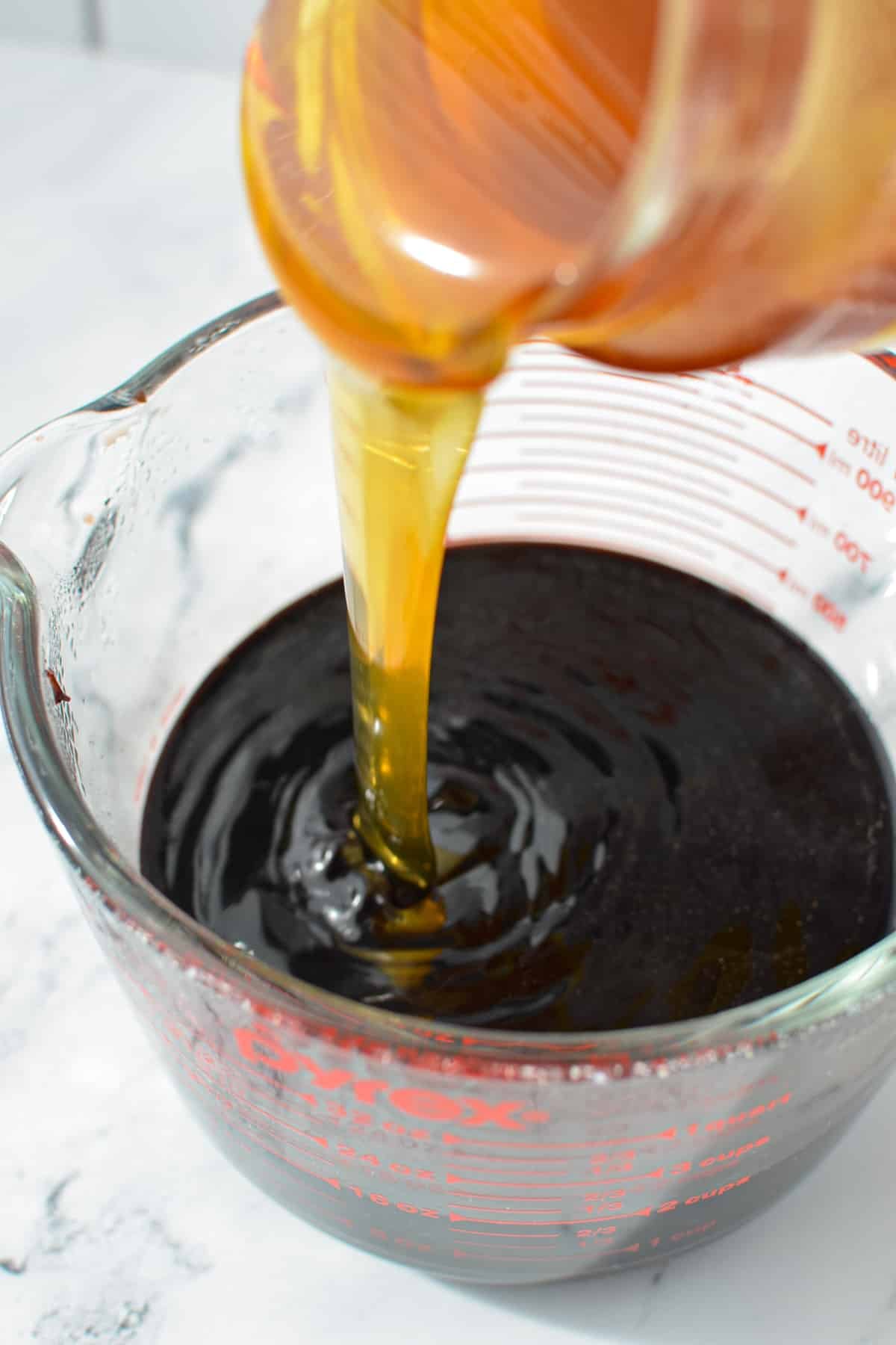 Adding honey to a measuring cup.